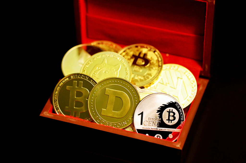 Golden cryptocurrency coins including Dogecoin and Bitcoin in a treasure box with warm lighting Wallpaper