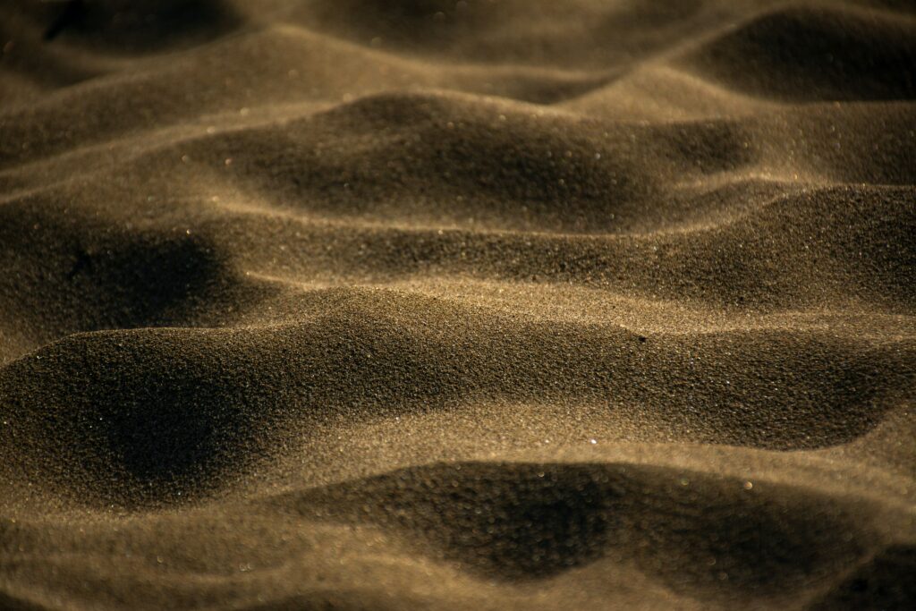 Macro close-up of desert sand waves texture warm golden tones minimalist natural wallpaper background