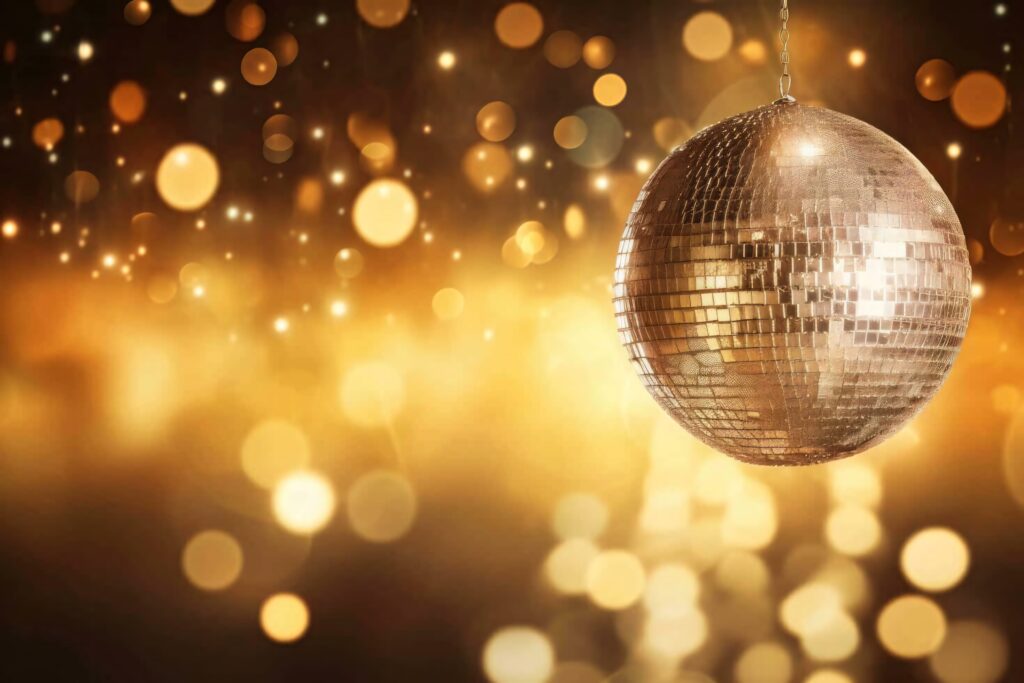 Shimmering disco ball glowing with golden bokeh background festive party celebration wallpaper