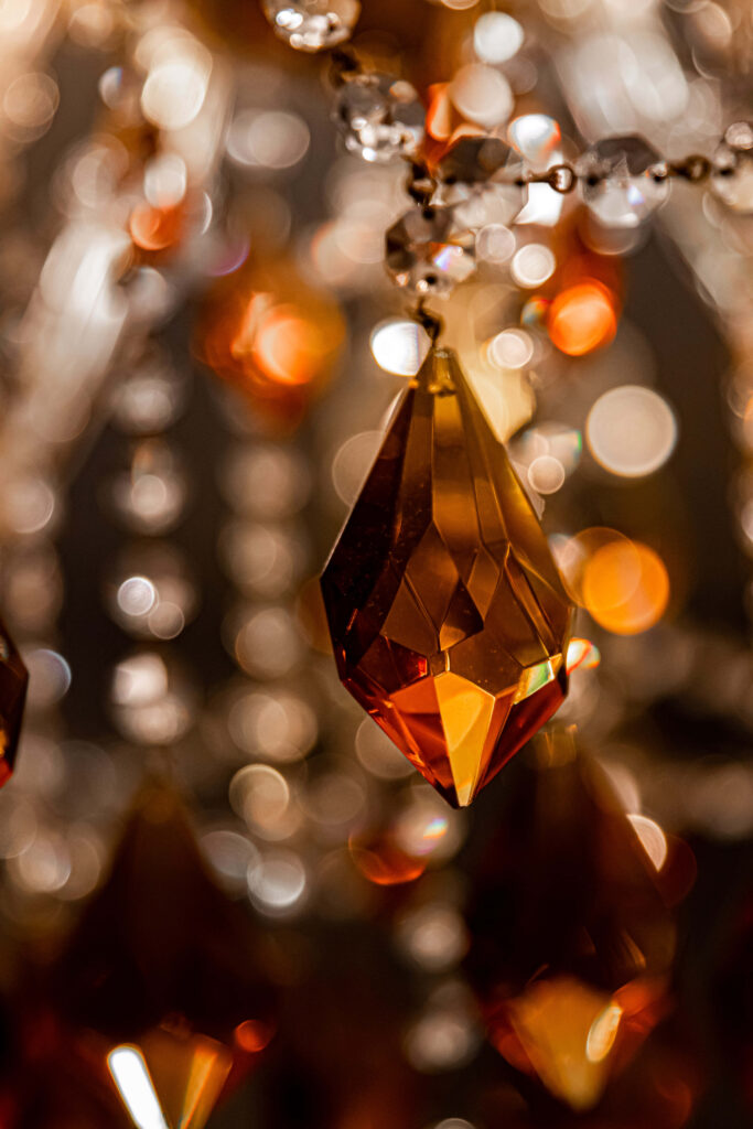Close up of faceted yellow gemstone crystal with warm amber hues and sparkling bokeh background Wallpaper