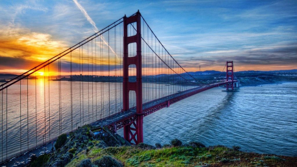 Golden Gate Bridge at sunrise with red span over blue San Francisco Bay peaceful wallpaper
