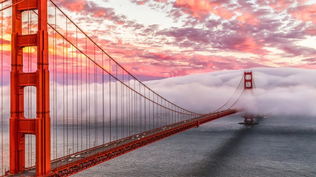 Golden Gate Bridge in San Francisco at sunset with fog and vibrant cloud-filled sky wallpaper