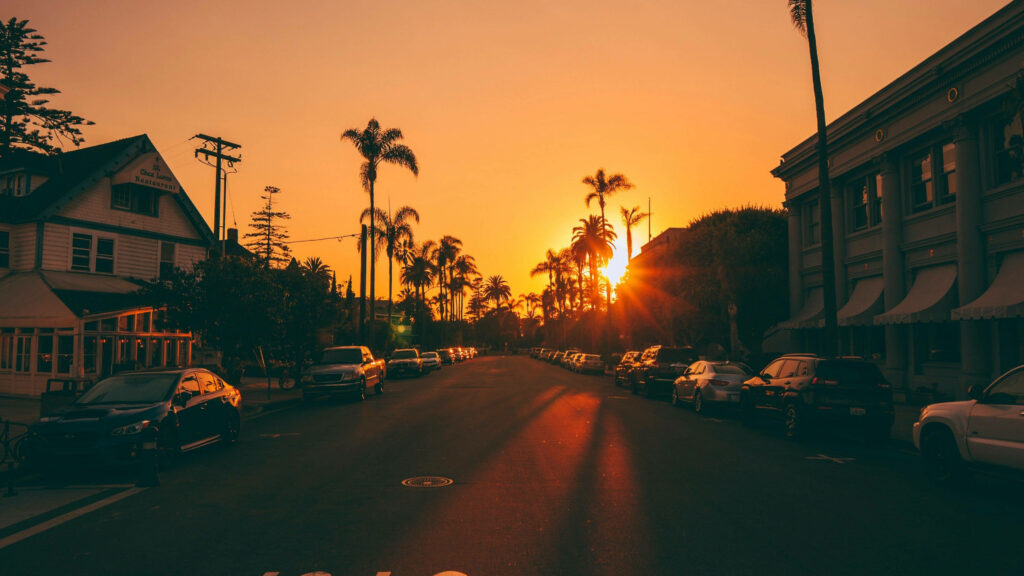 Twilight Drive: Spectacular Sunset Scene of Car-Filled Los Angeles Neighborhood Wallpaper