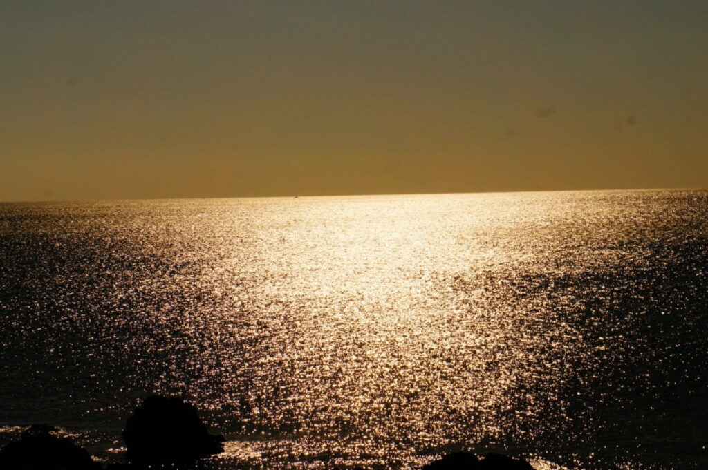 Glimmers of a Golden Sunset: Majestic Ocean Waves Embracing the Setting Sun Wallpaper