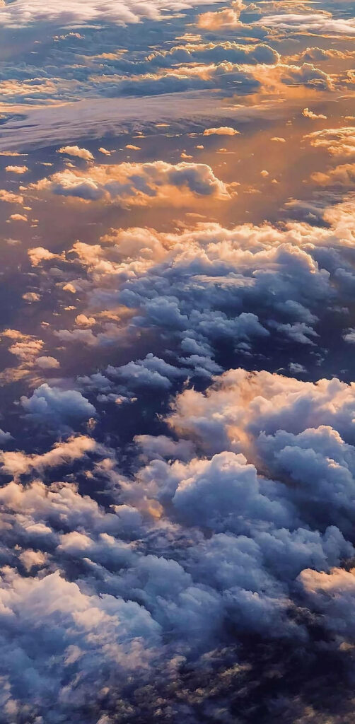 Wondrous Golden Skies: iPhone 12 Pro's Captivating Aerial Shot Reveals Sunlit Clouds in Stunning Reflection Wallpaper