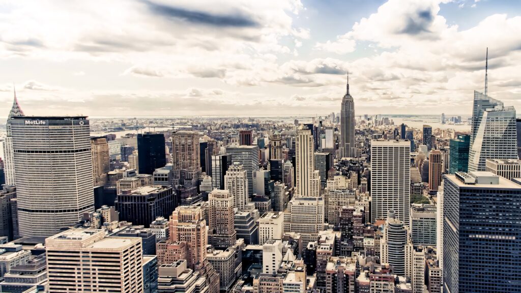 Manhattan skyline at sunset with golden light and dramatic clouds iconic New York City wallpaper