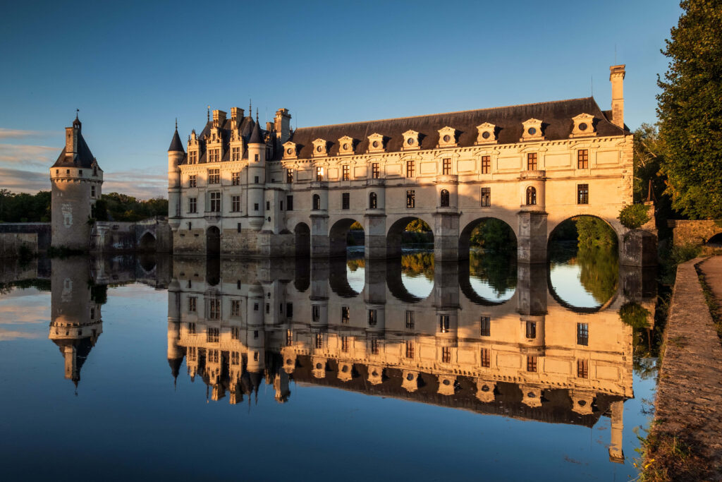 Château de Chenonceau at sunset reflecting in river with Renaissance arches and towers background Wallpaper
