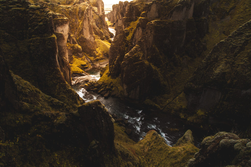 Dramatic gorge with rugged rocks and winding river in golden light natural landscape wallpaper background