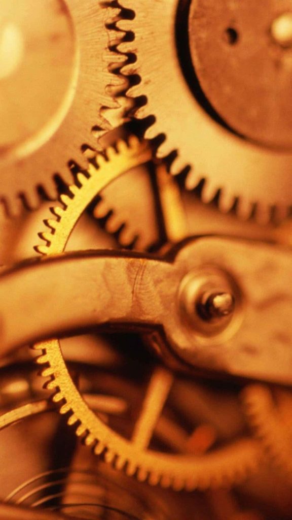 Macro close-up of golden mechanical gears with amber lighting for steampunk clockwork wallpaper