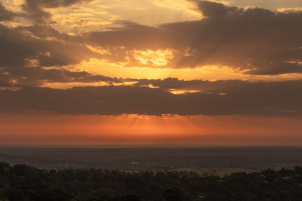 Sunset sky with golden orange clouds over tranquil horizon and expansive natural landscape wallpaper