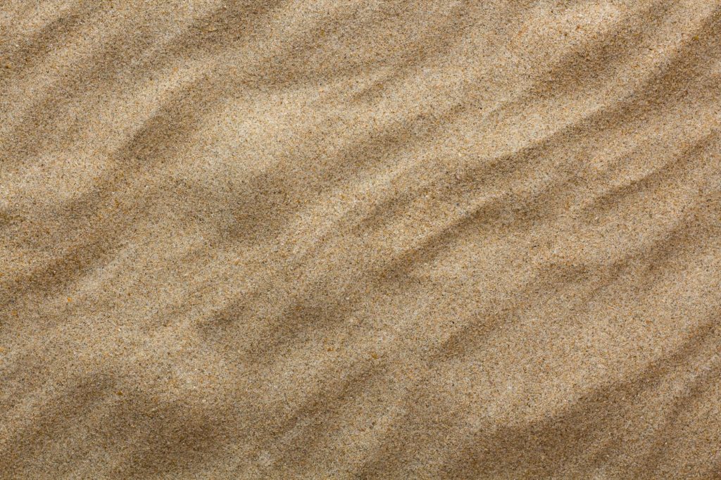 High-resolution close-up of golden sand ripples with natural light for serene desert wallpaper