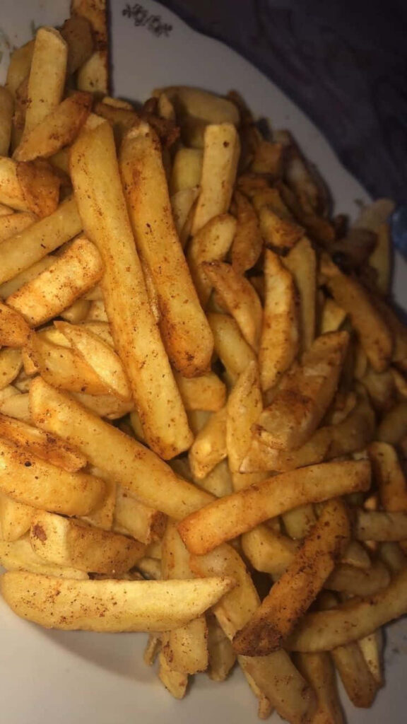 Golden Seasoned French Fries on Rustic Plate - Delicious Snack Wallpaper