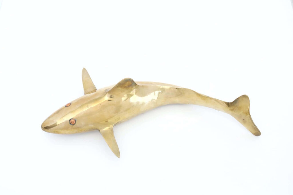 Golden shark sculpture wallpaper with metallic finish minimalist design on clean white background