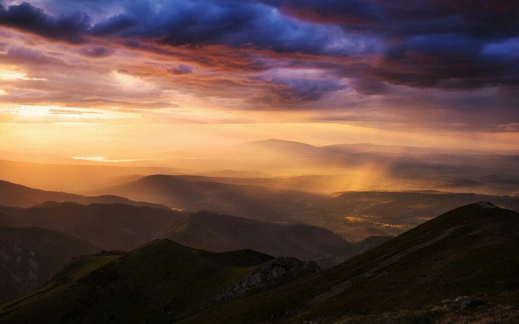 Golden sunlight over Carpathians and Tatras mountains with clouds and fog in serene valleys Wallpaper