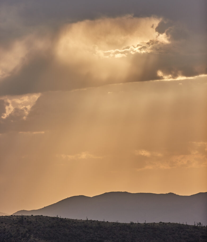 Golden sunlight breaks through clouds over peaceful serene mountain landscape at sunrise Wallpaper