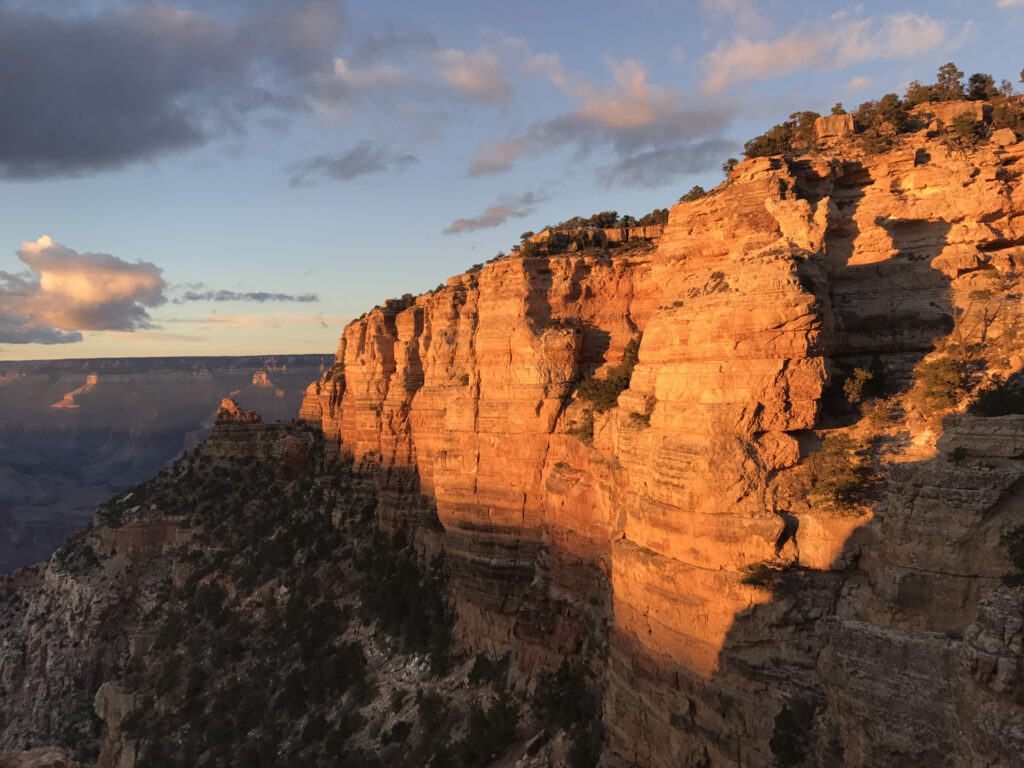 Stunning canyon landscape with golden sunlight on cliffs rugged textures and sparse greenery Wallpaper