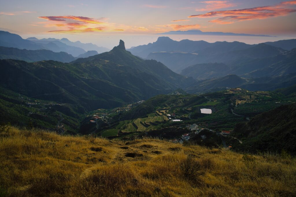 Breathtaking mountain landscape with rolling valleys lush green slopes and scattered rural houses Wallpaper