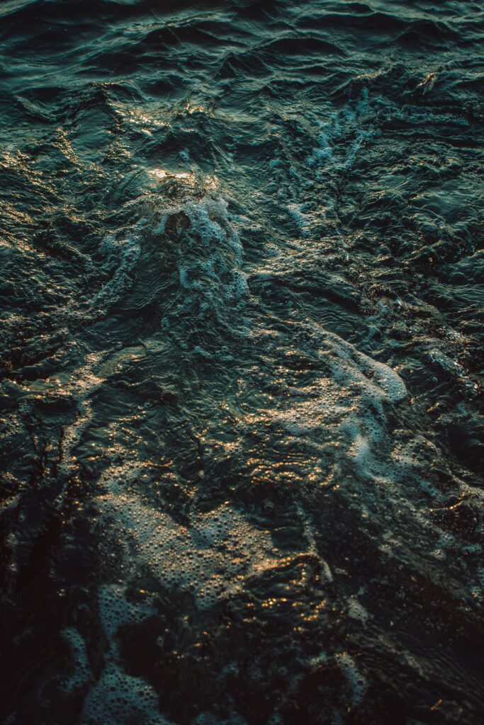 Dynamic sea waves with golden sunlight reflections and intricate foam patterns ocean wallpaper