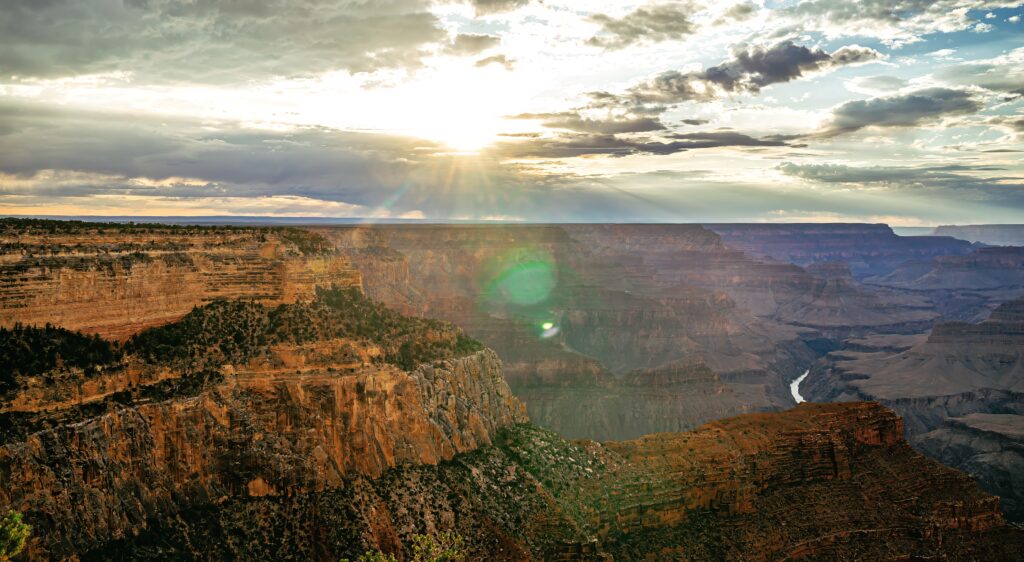 Breathtaking canyon landscape with rugged mountains and golden sunset over winding river Wallpaper