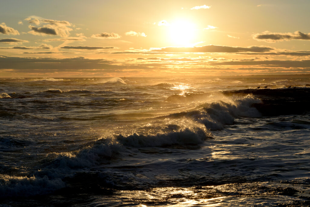 Ocean waves glowing gold at sunset bright glare on water serene powerful seascape wallpaper