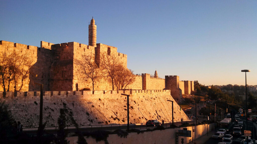 Ancient Jerusalem walls glowing in golden sunset light with historic architecture background Wallpaper