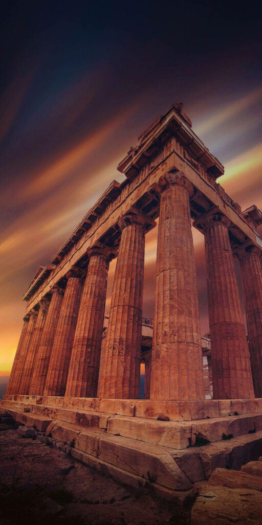 Ancient ruin pillars under golden sunset with dramatic clouds dusky sky classical architecture Wallpaper