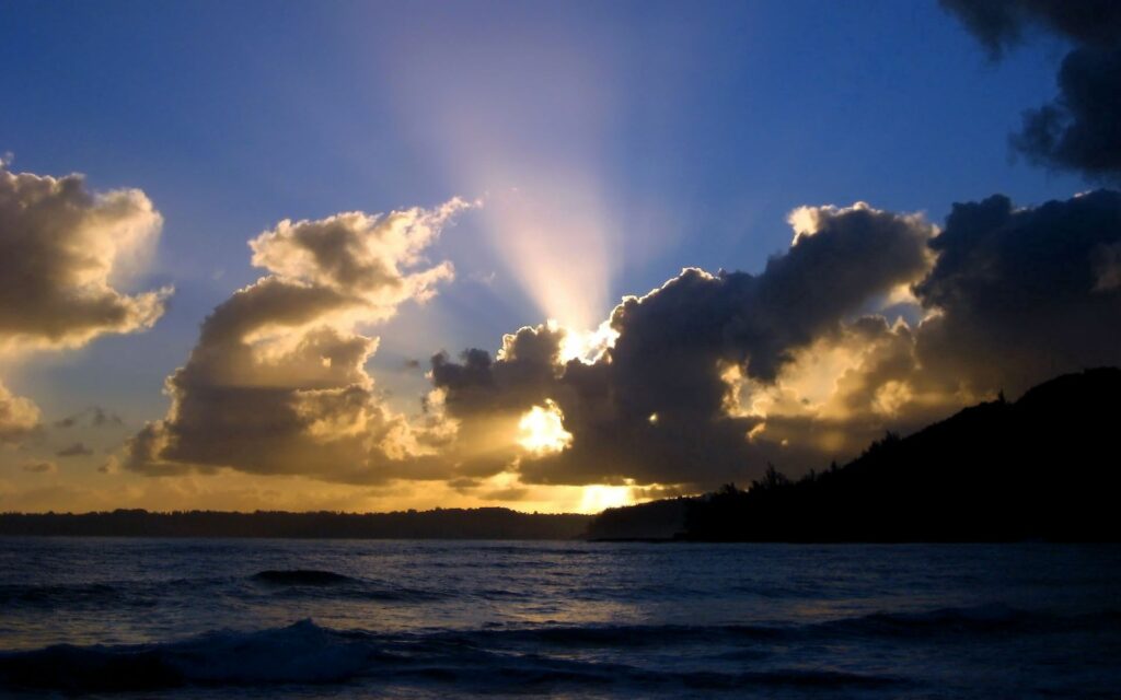 Golden sunset sky with dramatic clouds over calm sea serene evening seascape wallpaper background