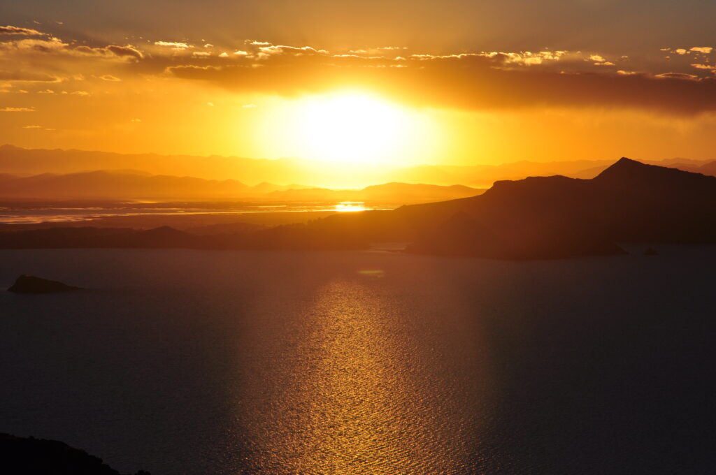 Breathtaking golden sunset over calm sea with glowing skyline and warm sunlight reflection wallpaper