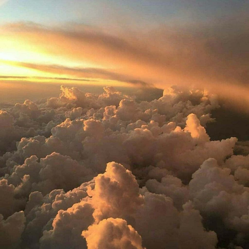 Aerial view of golden cumulus clouds at sunset creating a serene and tranquil sky wallpaper
