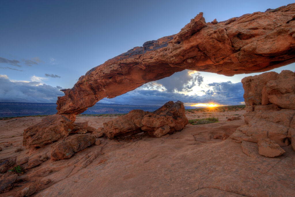 Natural rock arch at sunset with golden light and dramatic sky scenic landscape wallpaper