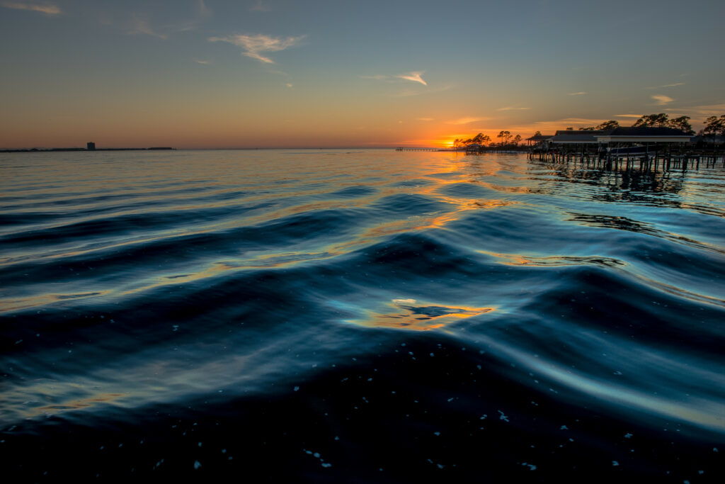 Golden sunset over serene sea with gentle waves and rich blue water high resolution wallpaper