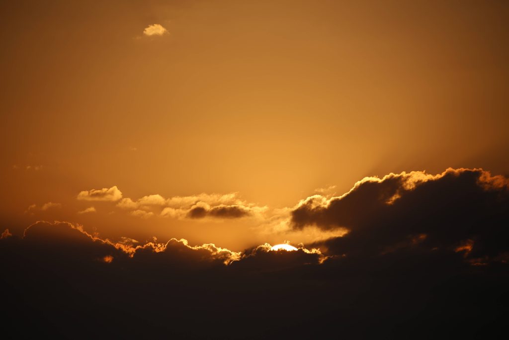 Golden sunset sky with glowing sun and dramatic cloud silhouettes high quality wallpaper