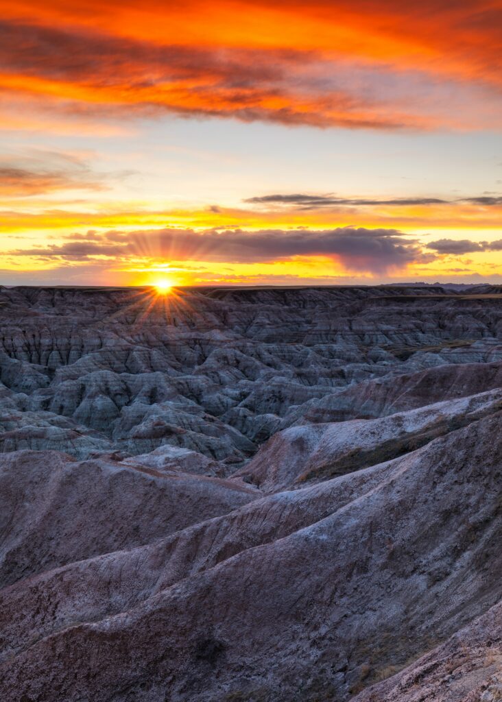 Golden sunset over rugged rocky formations under a vibrant dusk sky natural landscape wallpaper