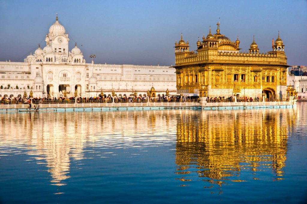 Golden Temple Amritsar gold-leafed sanctum reflected in Amrit Sarovar pool serene daylight wallpaper