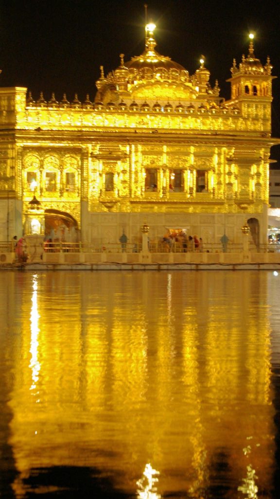 Golden Temple at night glowing with reflection in Amritsar holy pool spiritual architecture wallpaper
