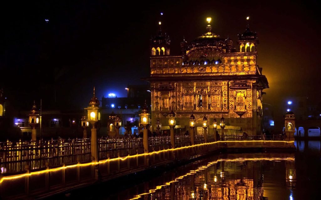 Golden Temple illuminated at night reflecting on Amrit Sarovar pool serene Sikh shrine wallpaper
