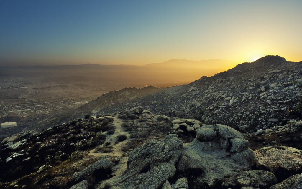 Twilight mountain landscape with rocky terrain bathed in soft golden sunset light wallpaper background