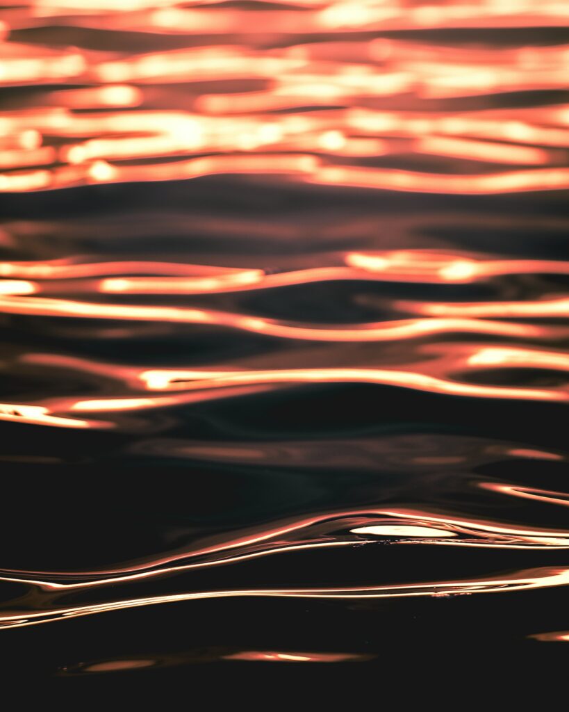 Abstract golden waves of water creating smooth flowing patterns and serene reflective surface Wallpaper