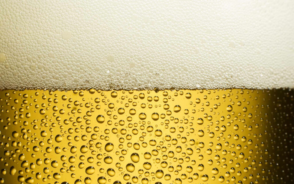 Close-Up Golden Yellow Beer Wallpaper: Refreshing Foam & Texture