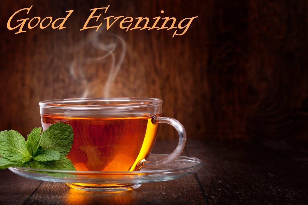 Steaming glass cup of amber Good Evening tea with fresh mint on dark wooden background Wallpaper