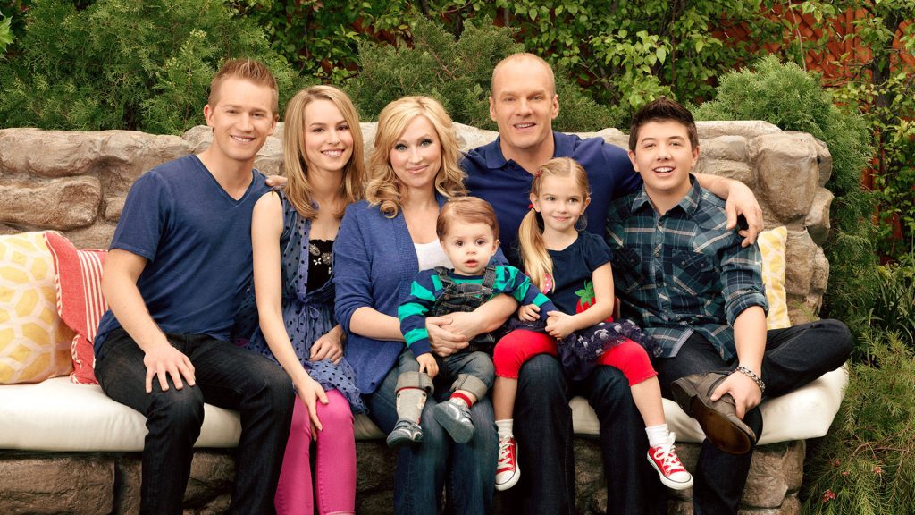 Good Luck Charlie family portrait with Duncan members posing by rustic stone wall background Wallpaper