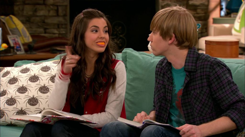 Victoria Justice and Jason Dolley pose humorously with orange slice in Duncan living room wallpaper