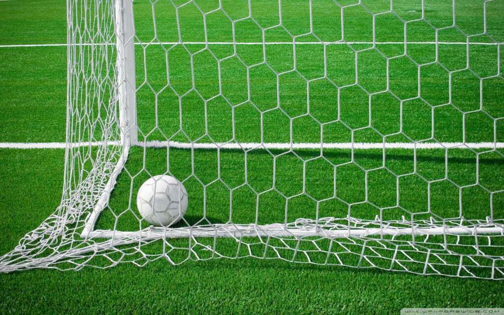 Spectacular Goal: Capturing the Thrilling Soccer Ball Soaring into the Net at the Vibrant Stadium Wallpaper