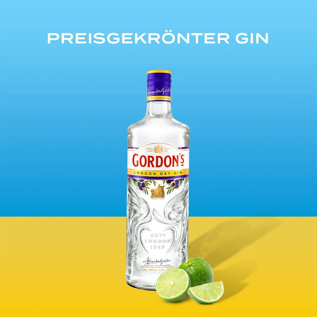 Gordons London Dry Gin bottle with fresh lime slices on vibrant blue and yellow background wallpaper