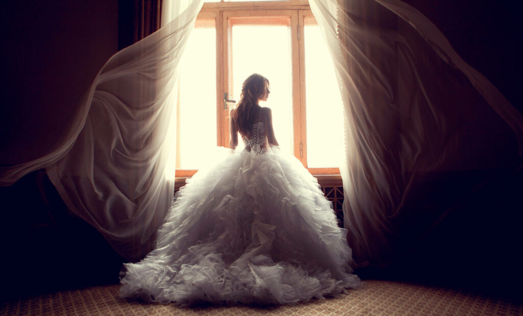 A Vision of Elegance: Enchanting Wedding Bride amidst Graceful Curtains Wallpaper