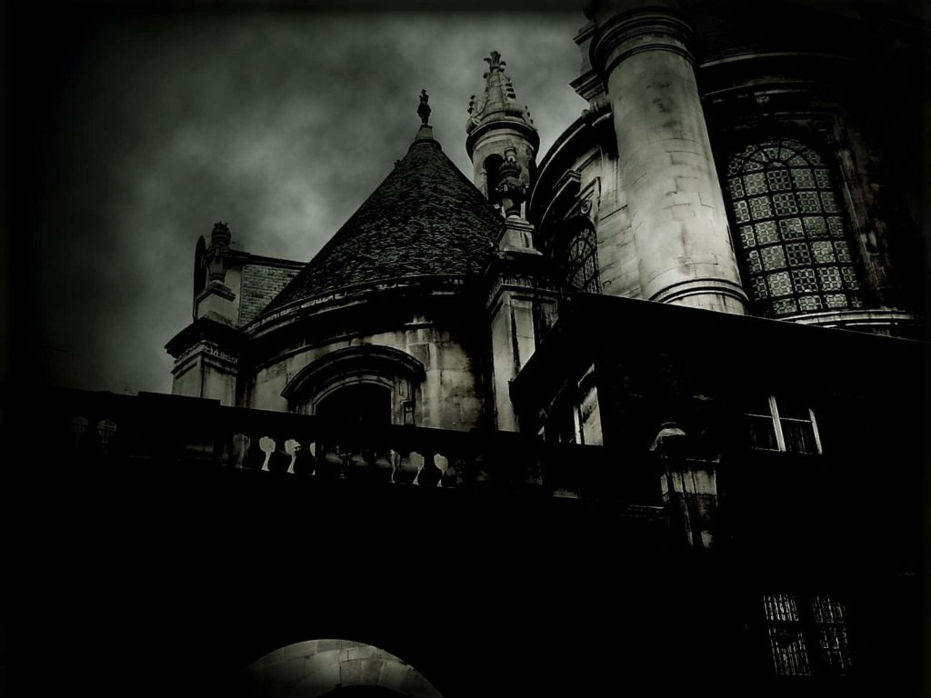 Gothic wallpaper of ancient stone cathedral with spires and lattice windows under dark sky