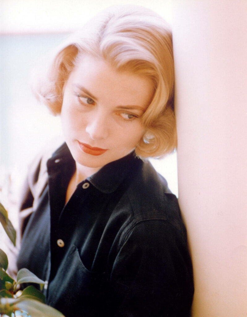 Portrait of Grace Kelly leaning on pillar with serene expression and timeless elegance wallpaper