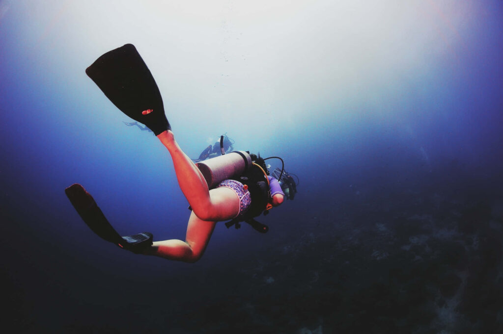 Scuba diver exploring deep blue ocean with vibrant lighting serene underwater adventure wallpaper