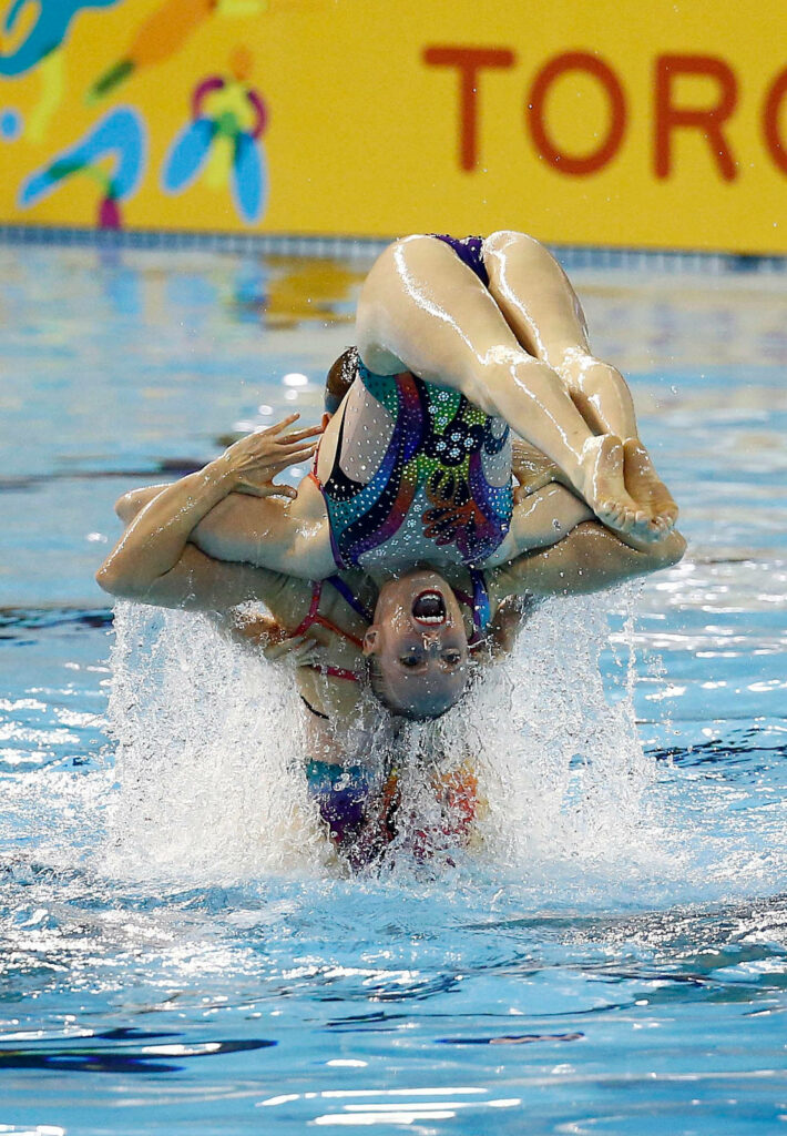 Vibrant Synchronized Swimming Duo Wallpaper: Graceful Aquatic Artistry