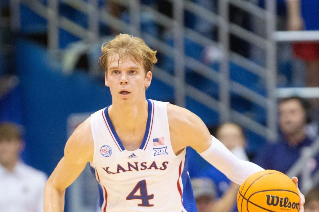 Kansas basketball star Gradey Dick dribbling Wilson ball in white number 4 Jayhawks jersey wallpaper